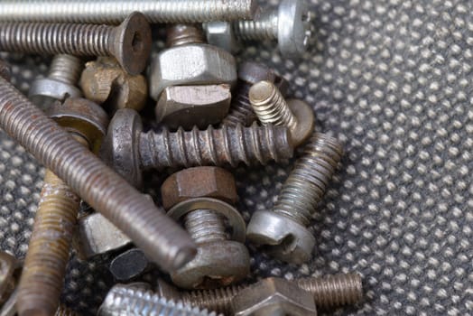Several old screws on a grey texile background