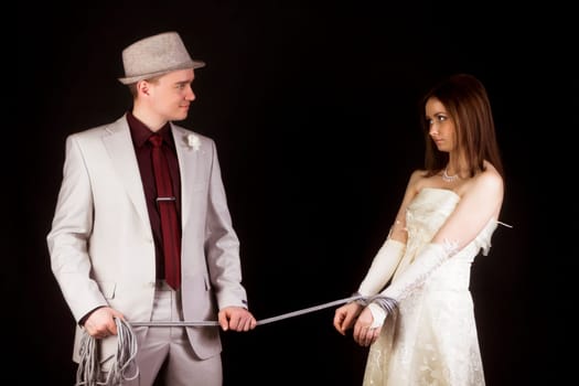 Wedding photo studio. Groom snared rope bride. fun