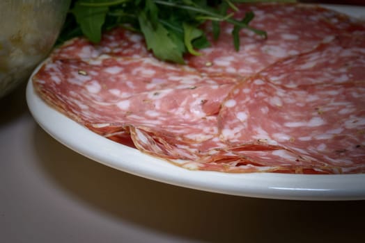 A Tipical Tuscany italian salami called finocchiona with rucola, tomato souce, mozzarella, tipical ingradients for italian pizza