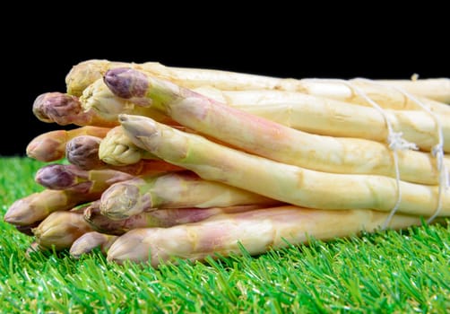 a bunch of fresh asparagus on the black background