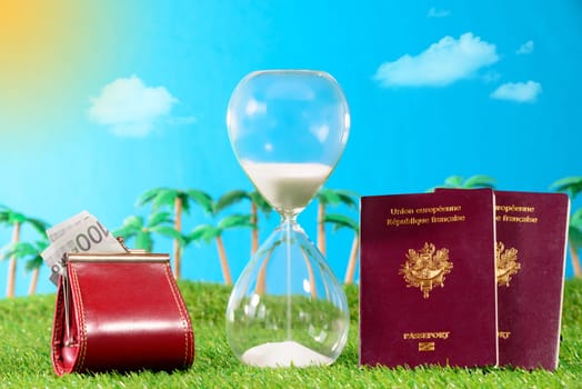 french passports and hourglass to the holidays on grass