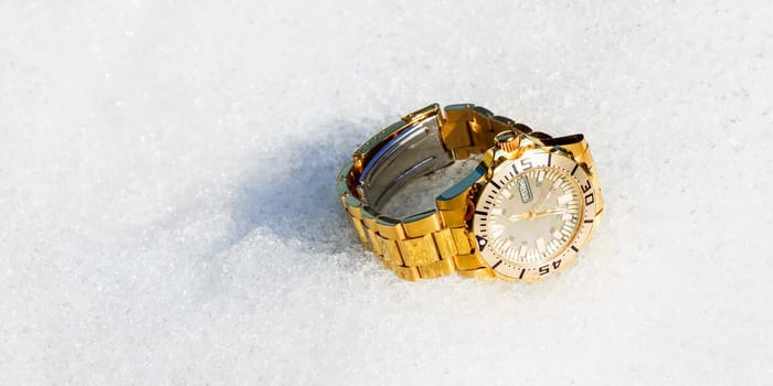 Golden watch in the snow