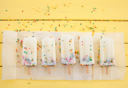Homemade vanilla ice cream on the stem with colorful sprinkles
