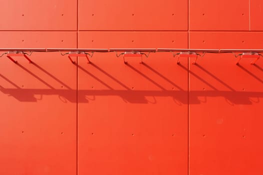 The lamp strips of a distinctive red facade cast a shadow.