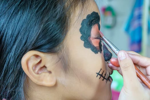 Close up the girl is making up sugar skull style. Day of The Dead. Halloween.