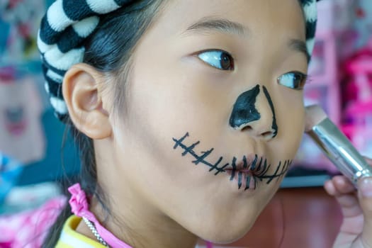 Close up the girl is making up sugar skull style. Day of The Dead. Halloween.
