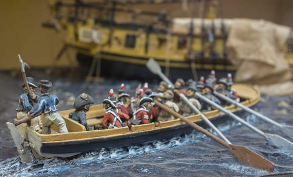 Badajoz, Spain - Dec 26th 2017: Royal Navy rowboat with surviving crew sail away from damaged warship. Diorama built by unknown artist