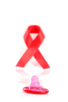 Aids ribbon and condom on white background.