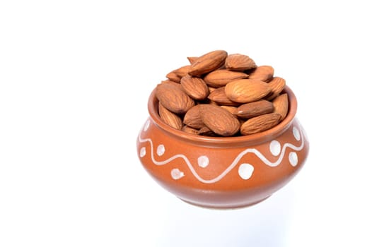 Almonds in a clay pot isolated on a white background