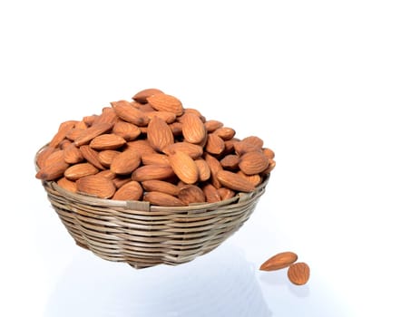 Almonds in a wooden basket with heap isolated on a white background