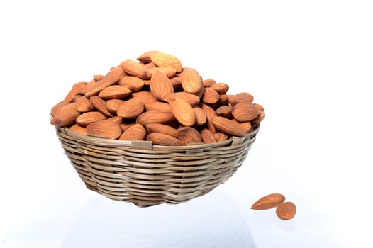 Almonds in a wooden basket with heap isolated on a white background