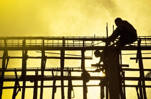 Silhouette construction site with worker on sunset. Construction concept.