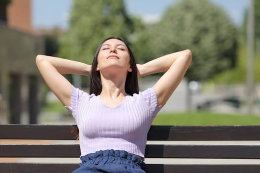 Mixed race woman relaxing in a bench in a park