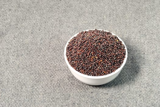 Brown Mustard Seeds in bowl on sackcloth