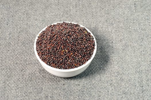 Brown Mustard Seeds in bowl on sackcloth