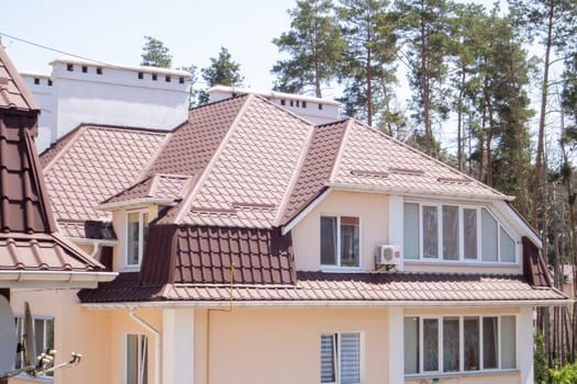 Roof on residential property with new brown corrugated metal roof tiles. Modern metal roof. Metal roofing