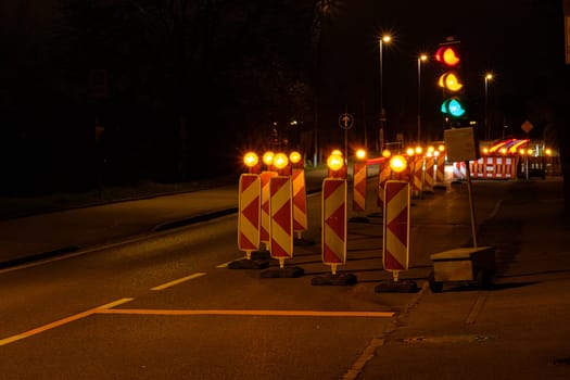 Traffic light at a construction site in night.