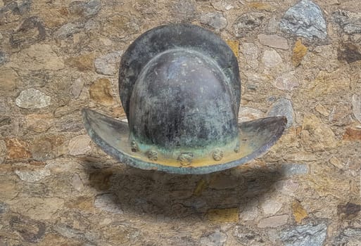 16h Century crested helmet morion. Isolated over stone wall background