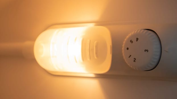 Orange light inside the refrigerator close-up. A lamp that turns on when the door is open to improve vision. Household appliances concept, changing the lamp in the freezer