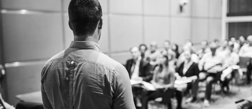 Speaker at Business Conference with Public Presentations. Audience at the conference hall. Entrepreneurship club. Rear view. Horisontal composition. Background blur.