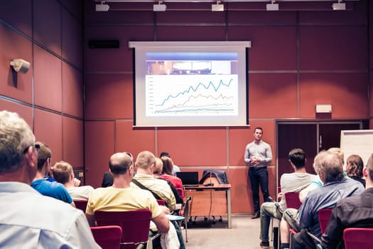 Speaker giving a talk in conference hall at business event. Unrecognizable people in audience at conference hall. Business and Entrepreneurship concept.