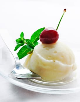 .Vanilla ice cream decorated with fresh mint and cherry