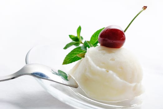 Vanilla ice cream decorated with fresh mint and cherry