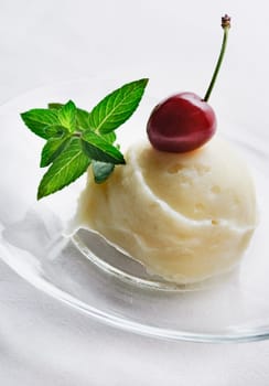 Vanilla ice cream decorated with fresh mint and cherry