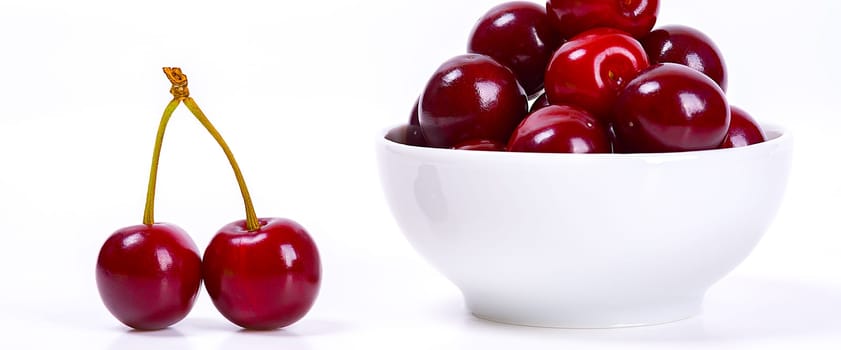 Cherry berries in a white cup on a white background. Isolated. Ripe cherries. Red delicious cherry. Place for advertising, lettering, logo, text, layout, mockup.