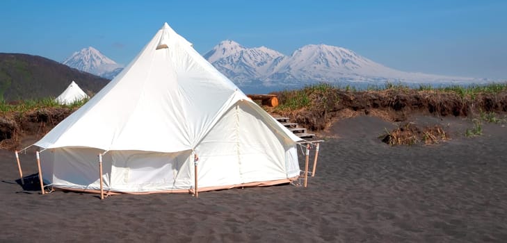 The Glamping house in summer and volcano, rural landscape, tent houses in Kamchatka peninsula