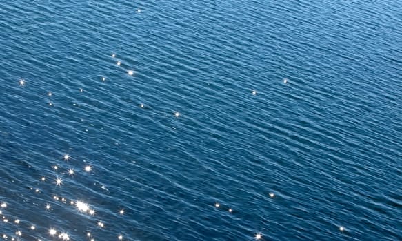 the surface of the blue sea with solar glare
