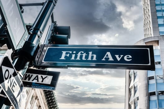 Blue Fifth Ave Sign with cloudy skiy, low angle in New York, USA