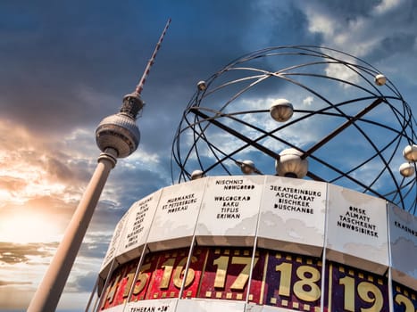 Berlin Television Tower, low angle with World clock in forefront. Sunset with cloudy sky...