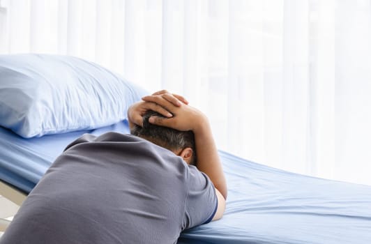 Depressed elderly spouse man mourning on patient bed for gone wife in hospital room