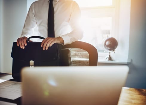 Business concept, man standing at desk with briefcase and laptop wearing a classic business outfit