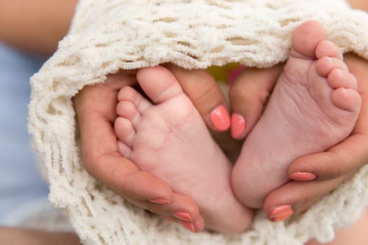 the legs of the child in the mother's arms