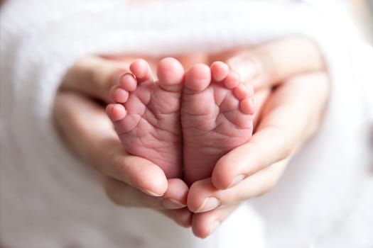 feet newborn baby in a white cloth in my mother's hands