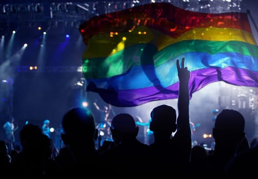 Pride community at a parade with hands raised and the LGBT flag - symbol of love and tolerance