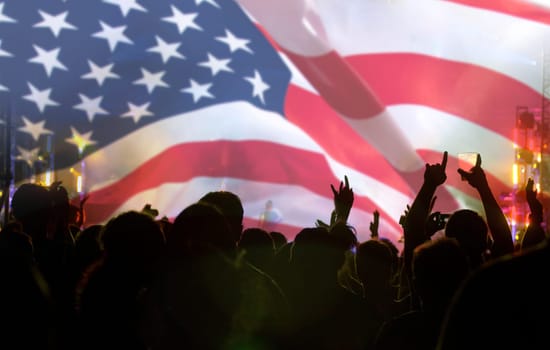 Crowd of people celebrating Independence Day. United States of America USA flag with fireworks background for 4th of July.