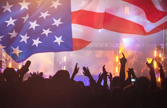 Crowd of people celebrating Independence Day. United States of America USA flag with fireworks background for 4th of July.