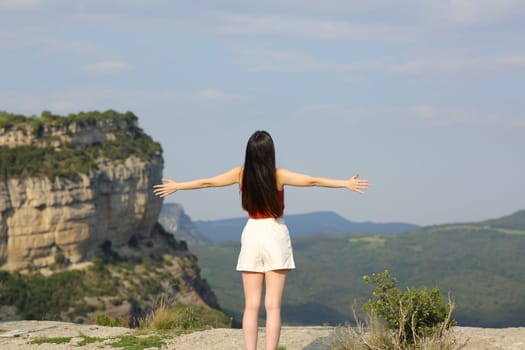Happy woman celebrating in the mountain