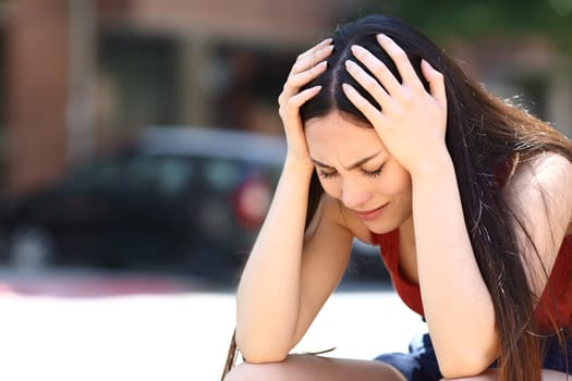 Sad asian woman complaining alone in the street