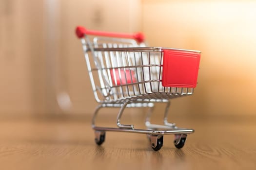 Online-Shopping and parcel service concept: Miniature shopping cart and cardboard boxes