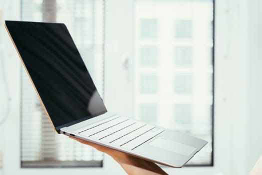 Young freelancer in black shirts holds up a very thin, elegant Ultrabook