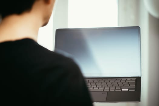 Young freelancer in black shirts holds up a very thin, elegant Ultrabook
