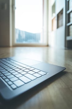 Cutout of a modern laptop keyboard on the wooden floor with text space