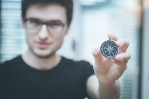 Young freelancer with compass holding in hand