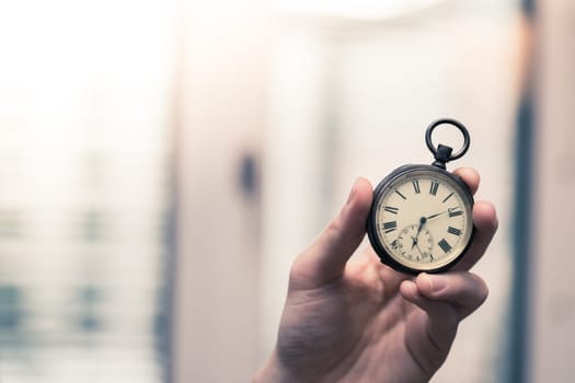 Time goes by: Man is holding a vintage watch in his hand, business context, copy space