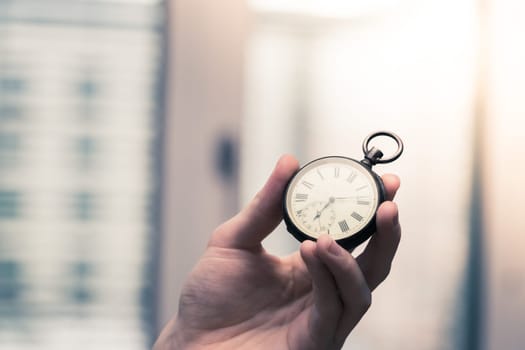 Time goes by: Man is holding a vintage watch in his hand, business context, copy space