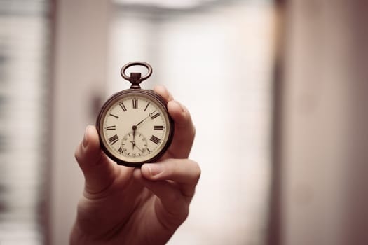 Time goes by: Man is holding a vintage watch in his hand, business context, copy space